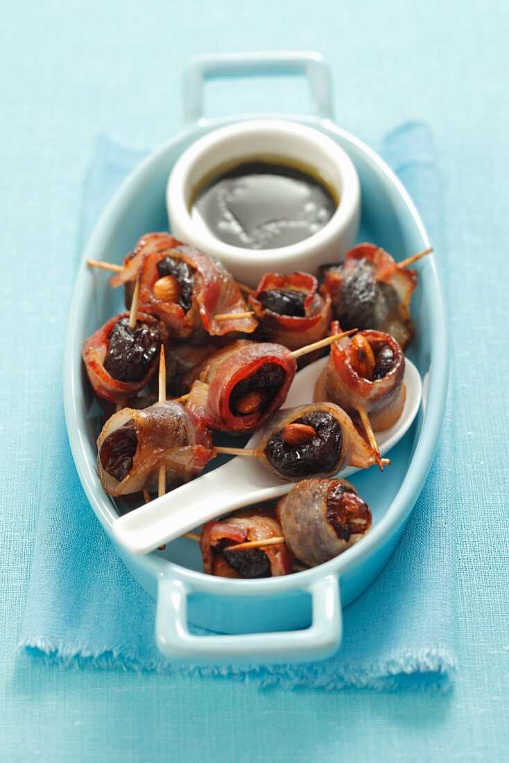 Dates wrapped in bacon with almonds and balsamic dressing