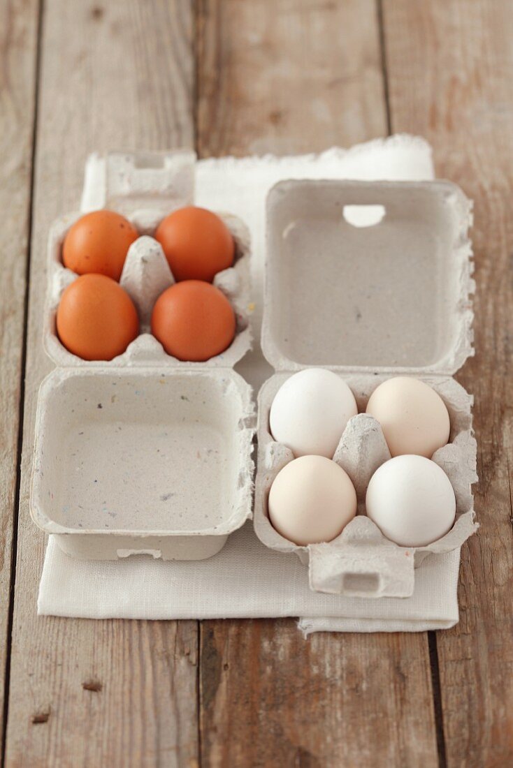 Braune und weiße Eier in Eierkartons