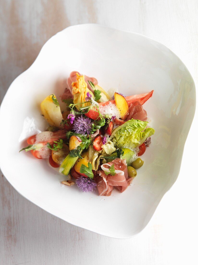 Tomato salad with ham, fruit and edible flowers