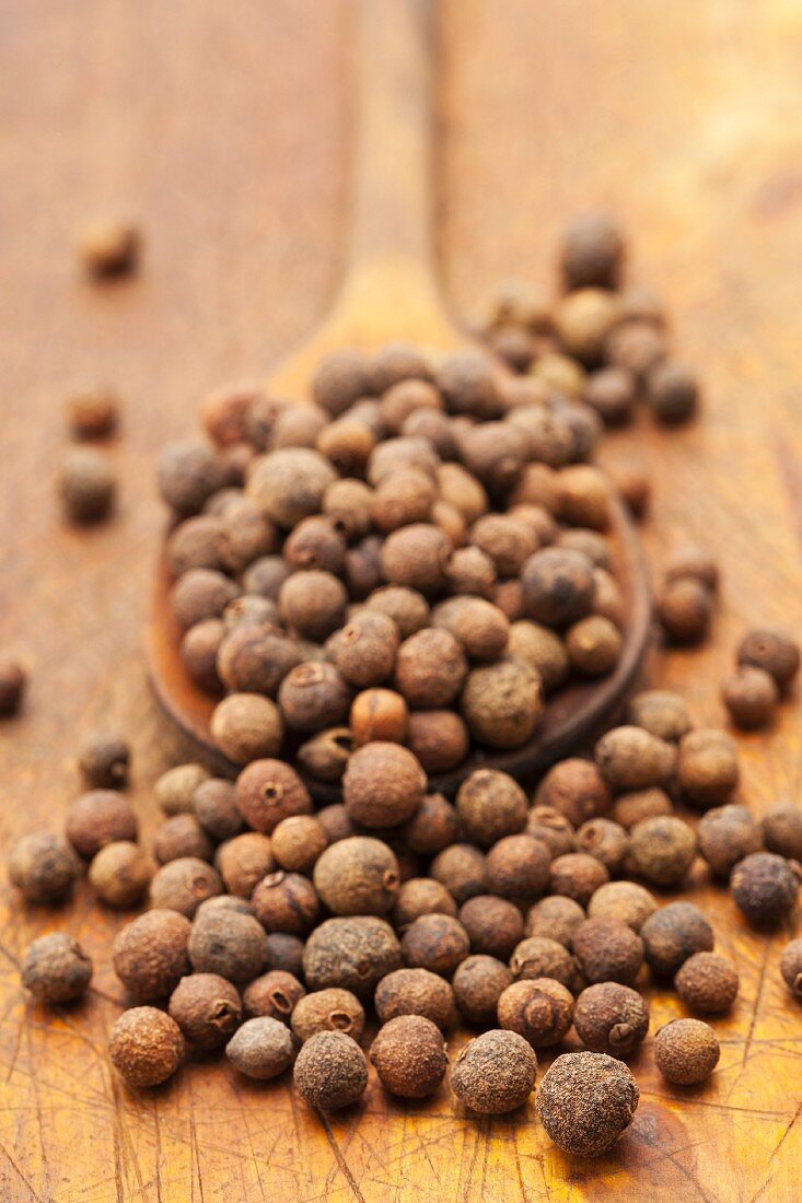 Allspice berries on a wooden spoon