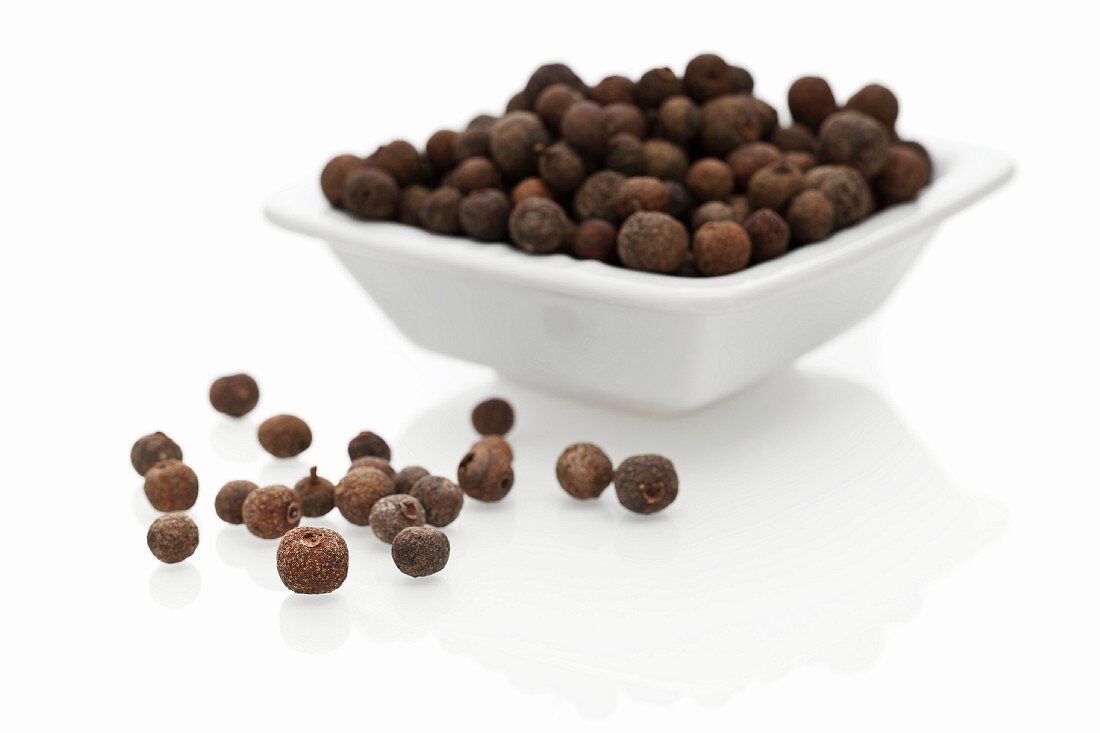 Allspice berries in a bowl and next to it