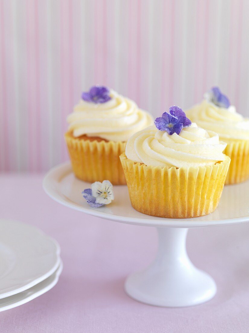 Cupcakes topped with lemon cream and violets