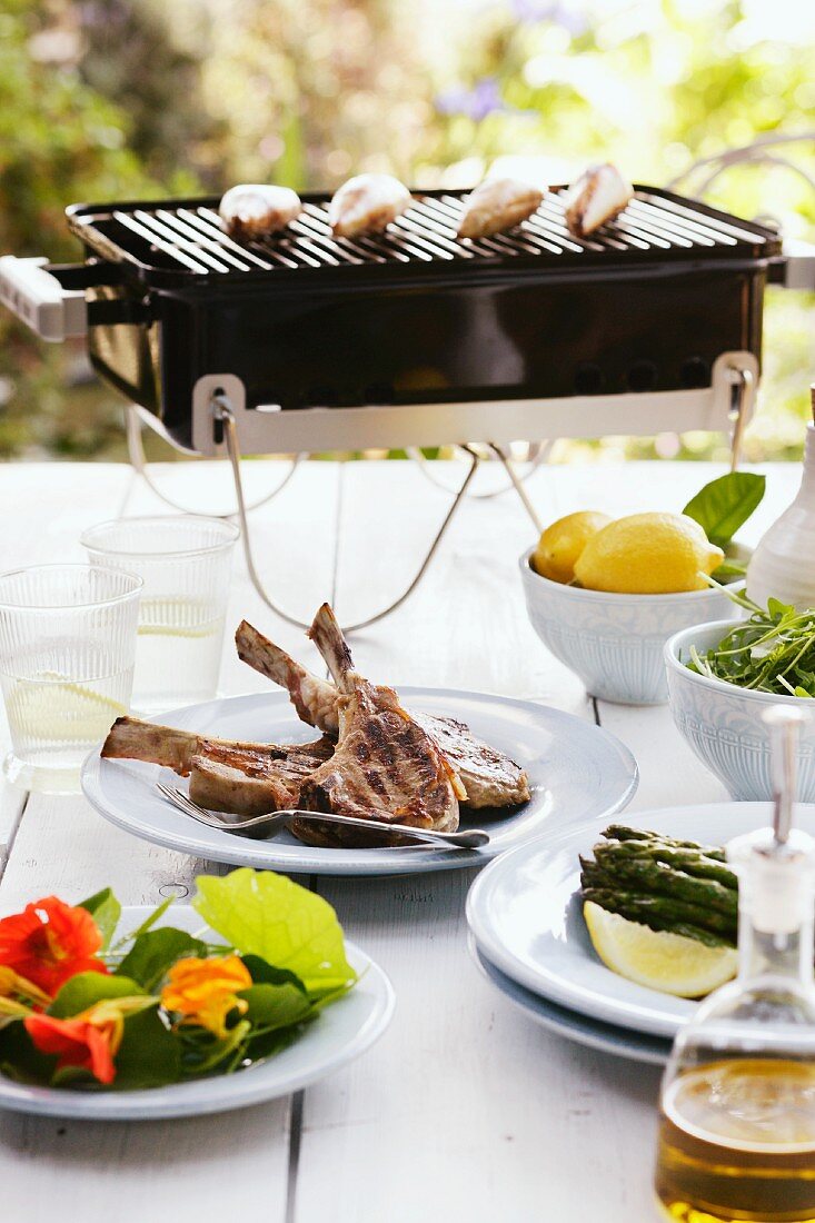A table laid outside with grilled lamb chops