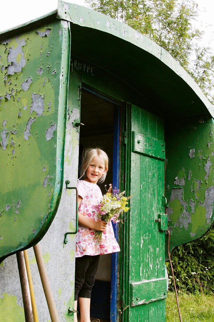 Blonde girl with bouquet in summer house