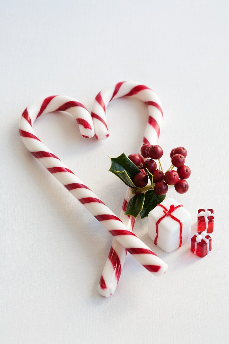 A candy cane heart with holly and glass decorations