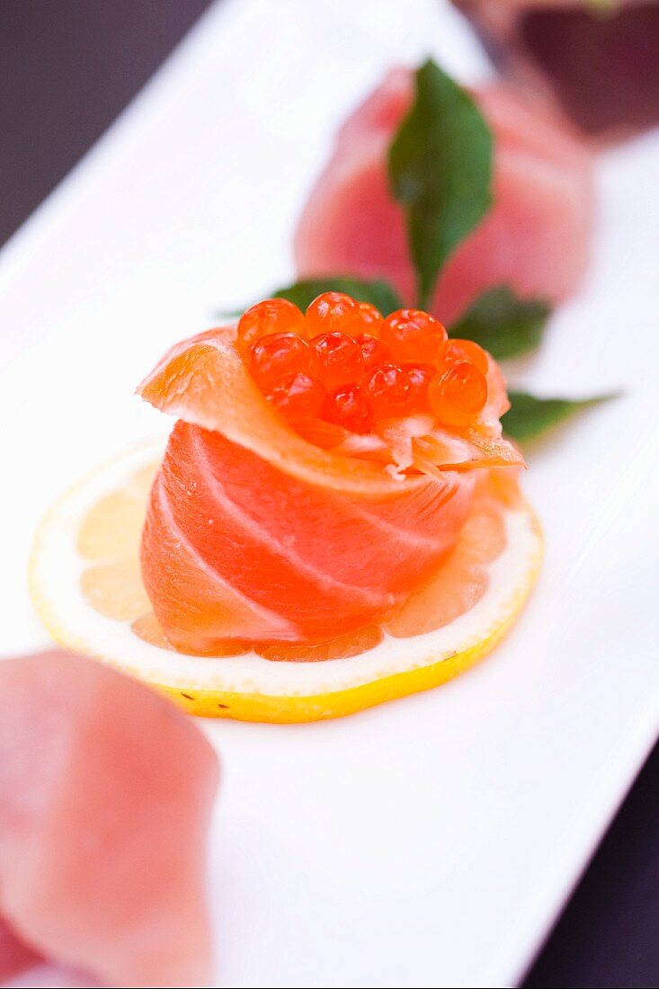 Salmon Sushi Topped with Caviar on a Lemon Slice; Assorted Sushi