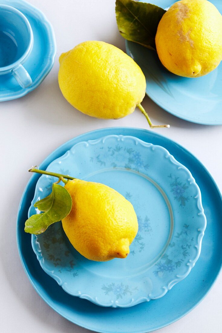 Bio-Zitronen auf blauen Tellern
