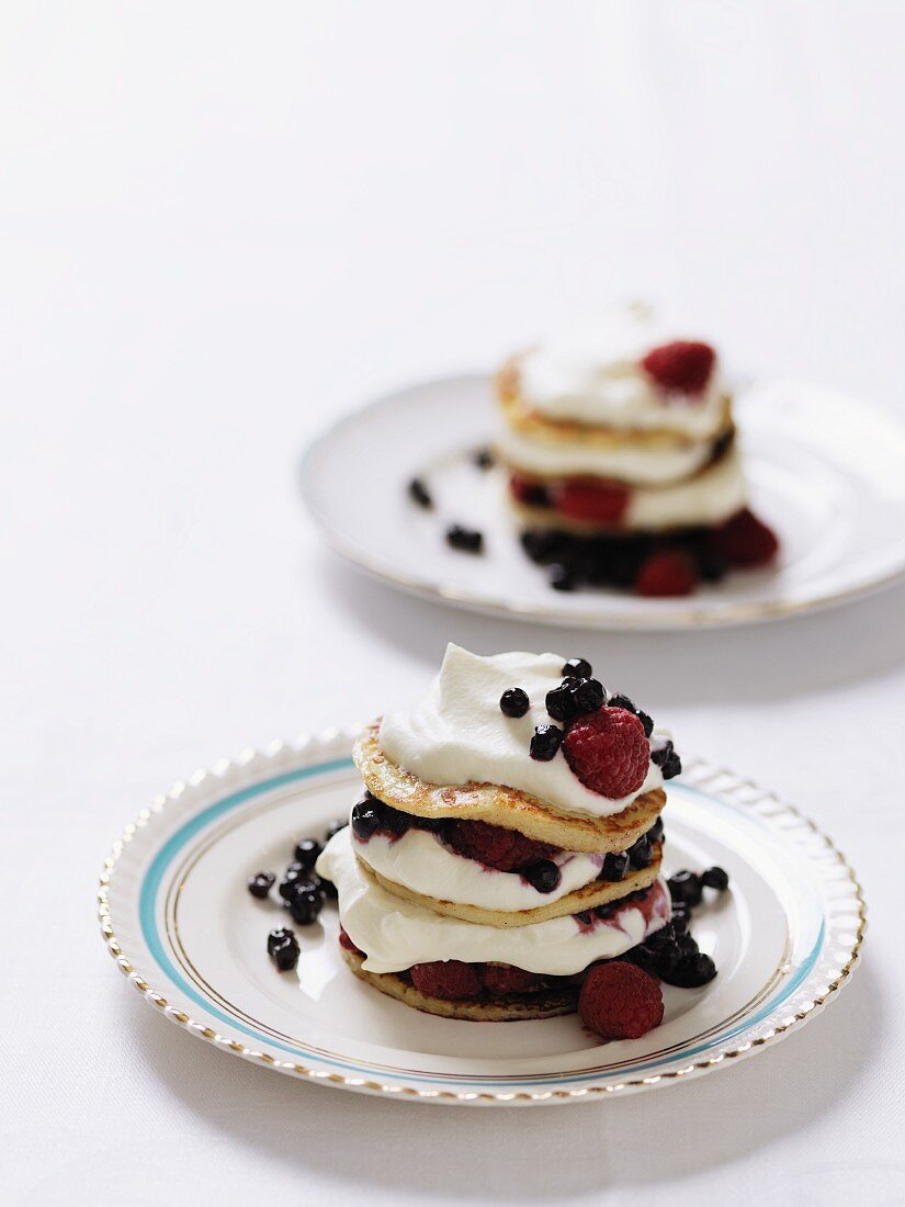 Pancakes topped with cream and berries