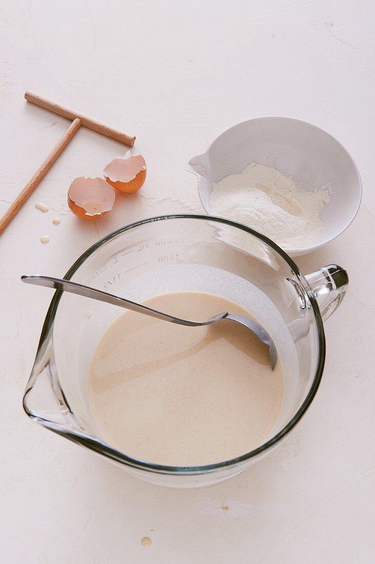 Crepe batter in a measuring jug with flour and eggs