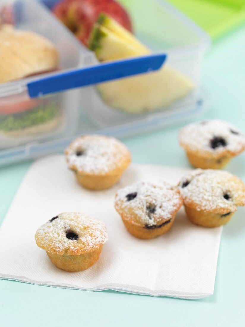 Zitronen-Blaubeer-Muffins, im Hintergrund Lunchbox