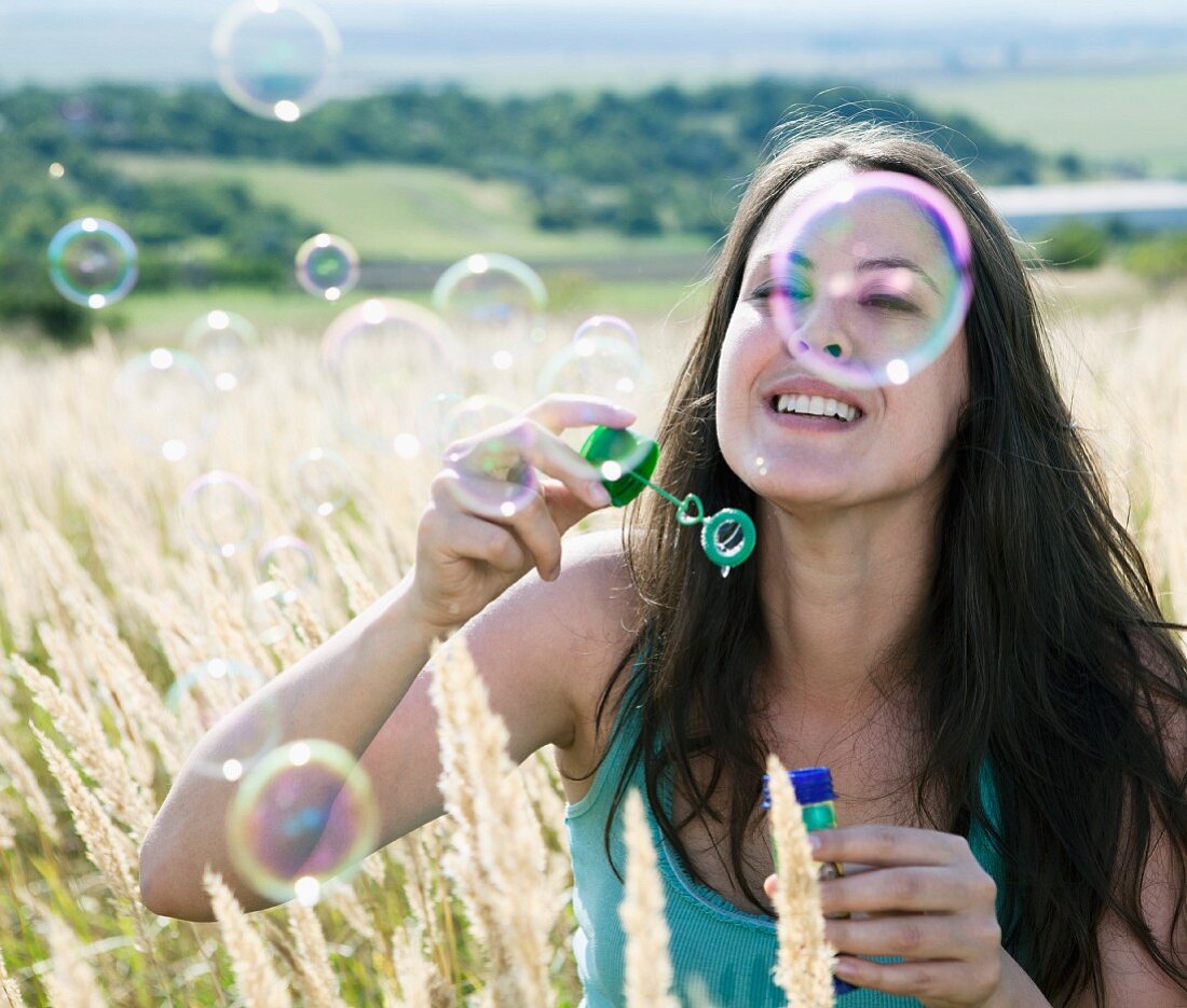 Woman blowing soap bubbles into the air