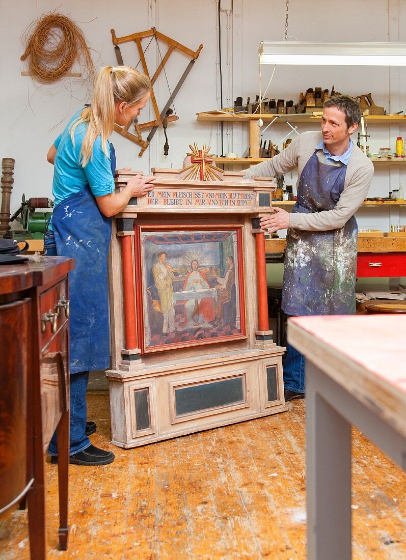 Cabinet makers restoring work of art
