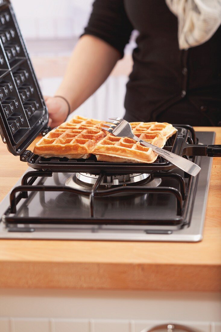 Waffeleisen mit frisch gebackenen Waffeln