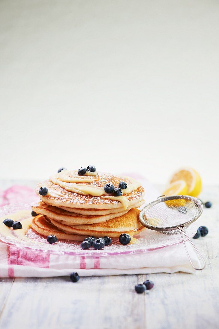 Stack of Pancakes Topped with Lemon Curd, Fresh Blueberries and Dusted with Powdered Sugar