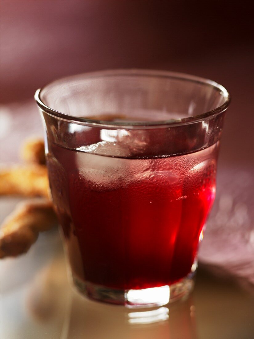 Elderberry syrup in a glass with ice cubes