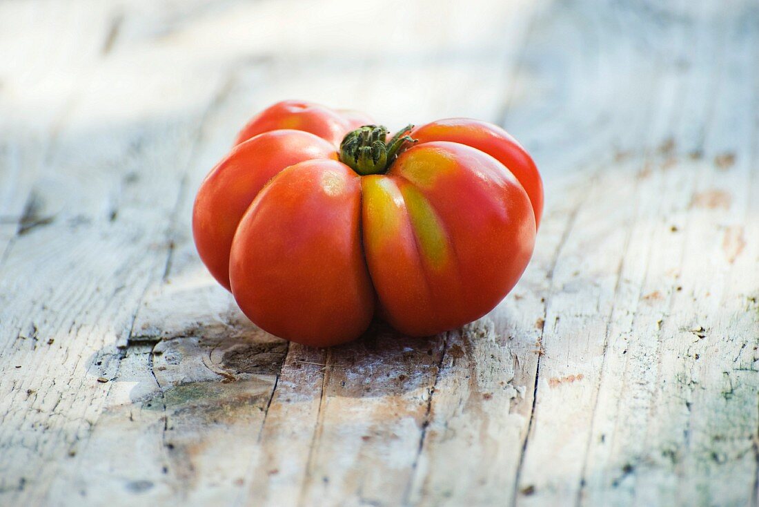 Eine Heirloom Tomate auf Holzuntergrund