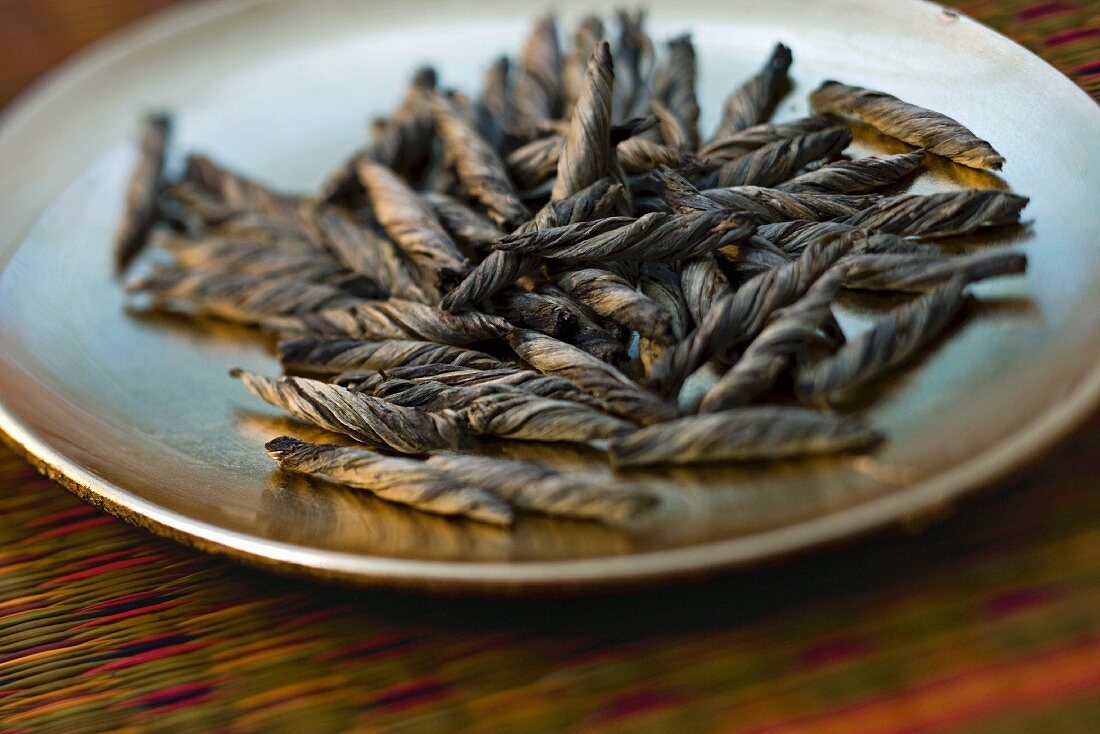 Twists of tea leaves on small plate