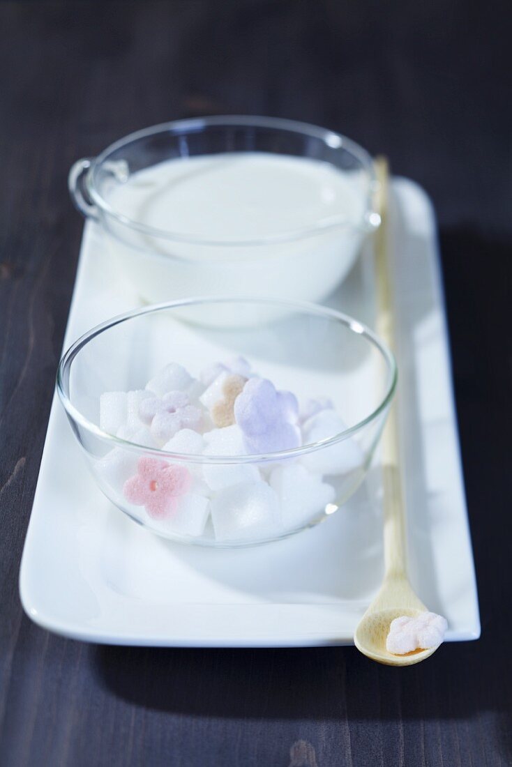 Zucker in Blütenform auf Tablett mit Löffel