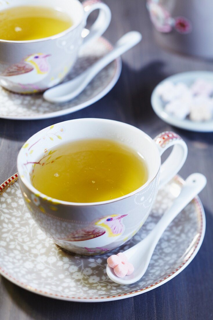 Teetasse mit Vogelmotiv und Zucker in Blütenform