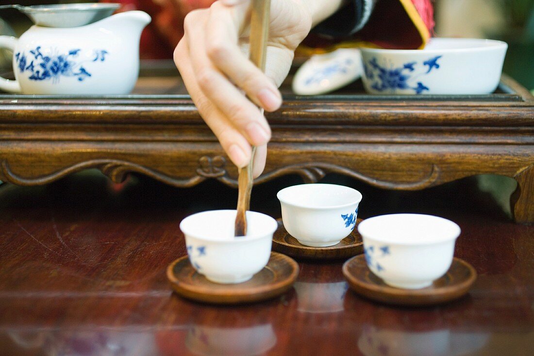Woman preparing tea, cropped view of hand