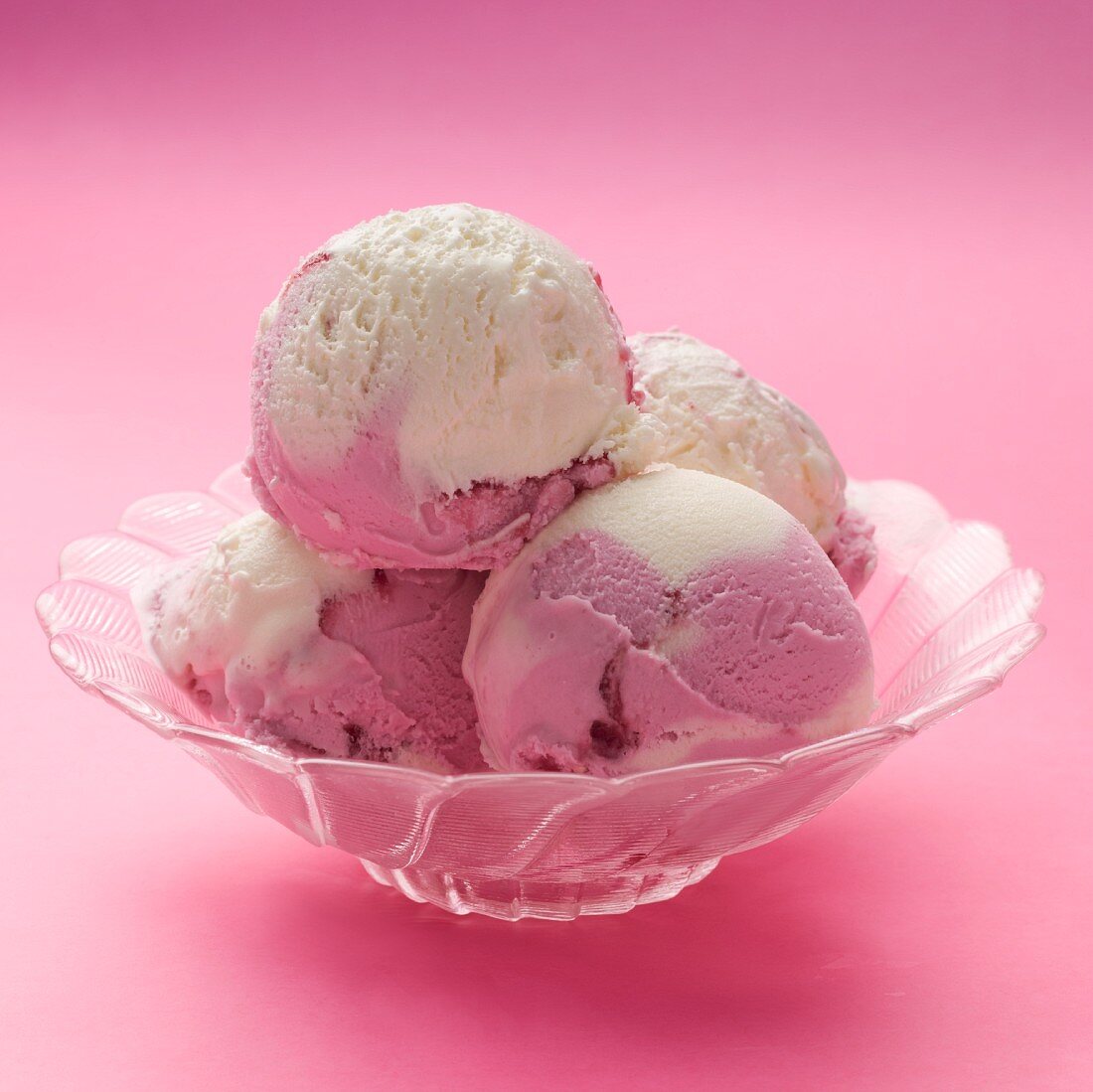 Raspberry and vanilla ice cream in a glass bowl