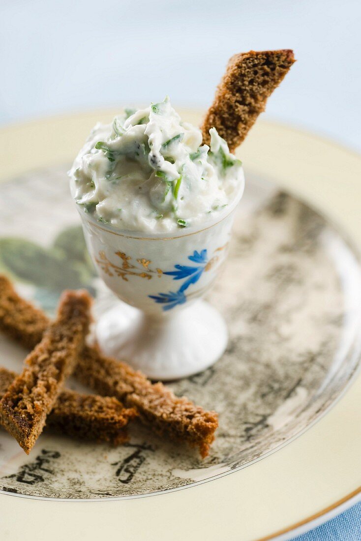 A goat's cheese and parsley dip with breadsticks