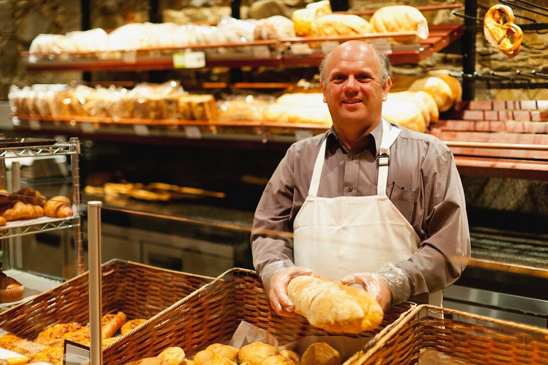 Freundlicher Bäcker hält ein Brot