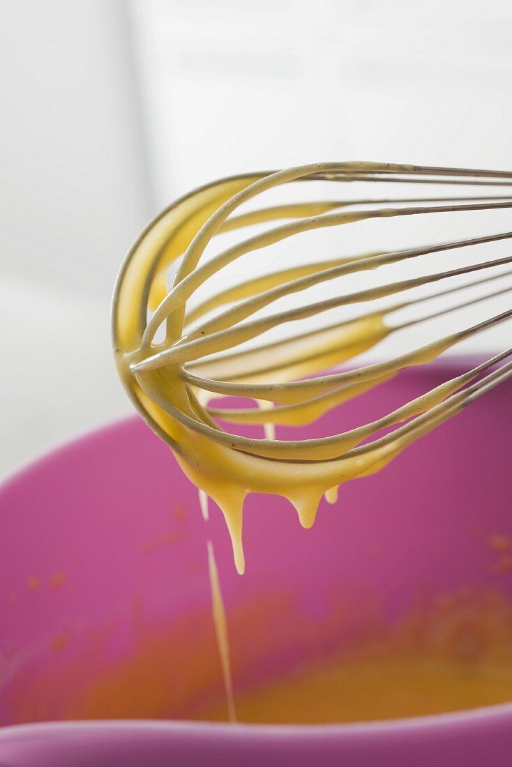 Liquid batter dripping from a whisk