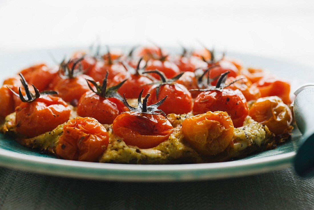 Pizza topped with cherry tomatoes, pesto and ricotta