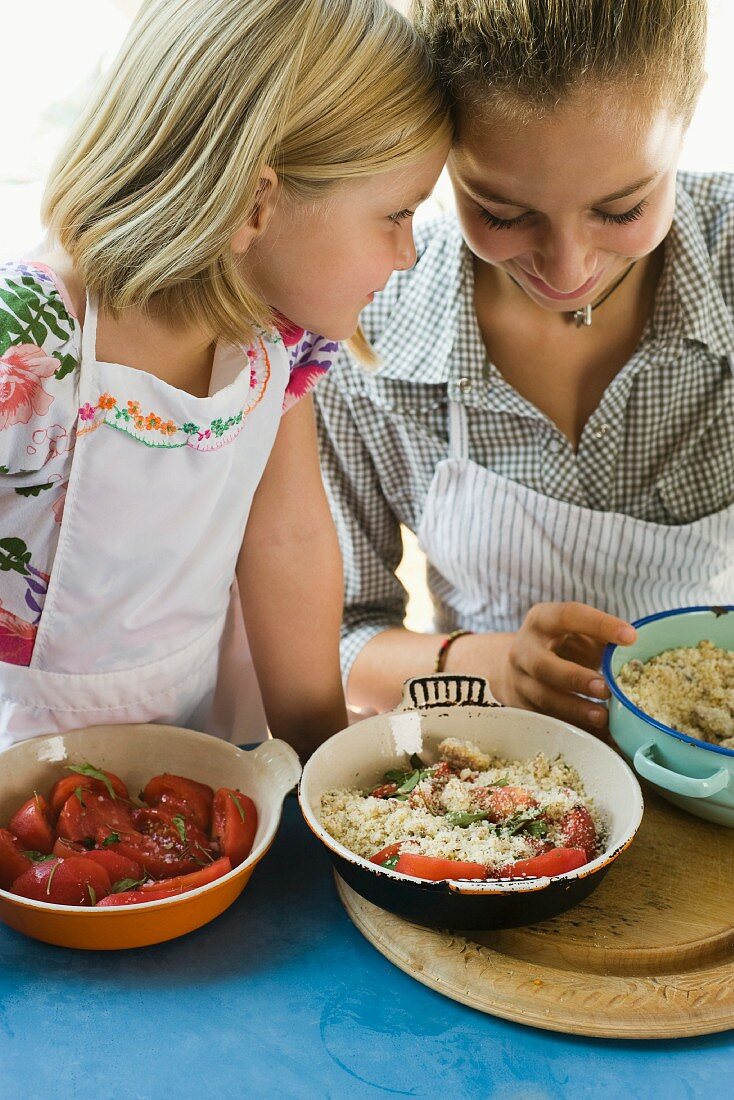 Zwei Schwestern kochen zusammen einen Auflauf