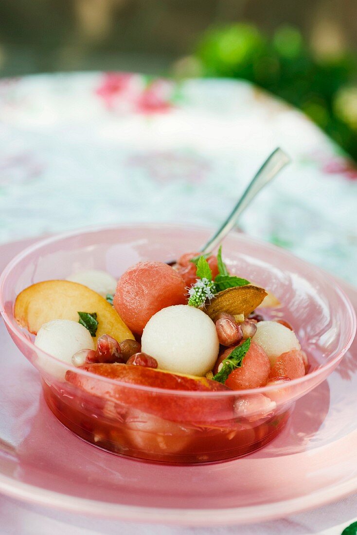 A summer fruit salad with pomegranate seeds and almonds