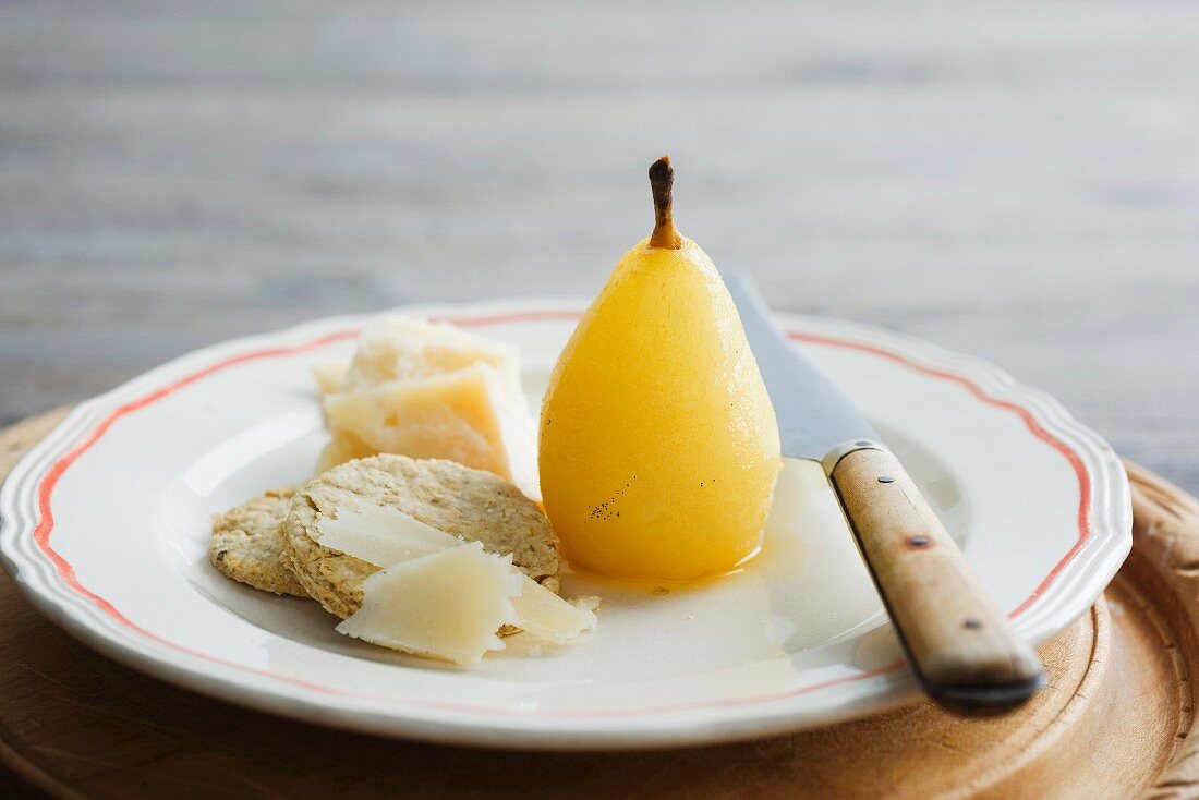 A poached pear with oat biscuits and Parmesan cheese