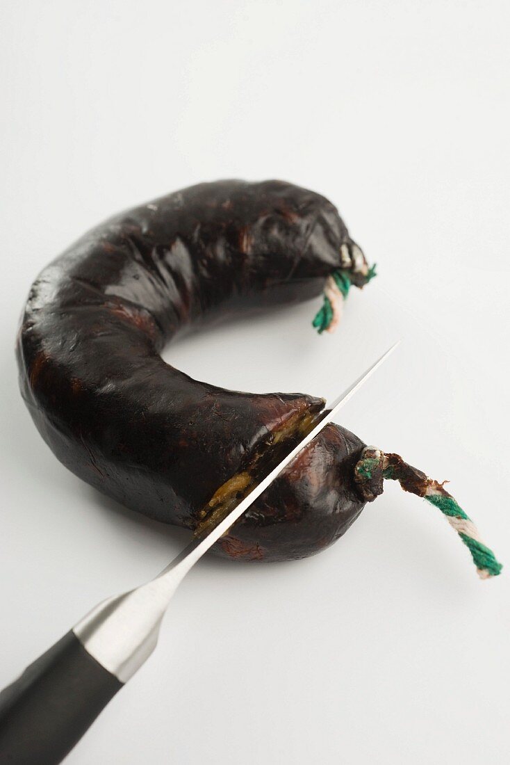 A black pudding being sliced