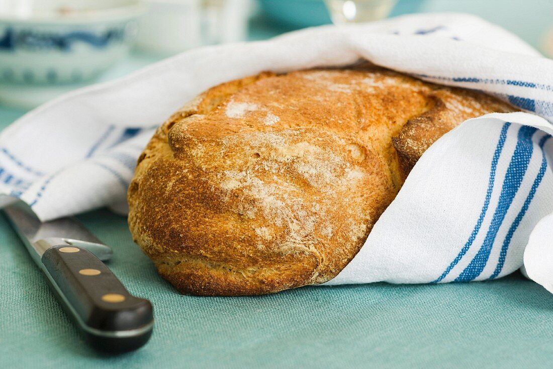 Freshly baked bread wrapped in a tea towel
