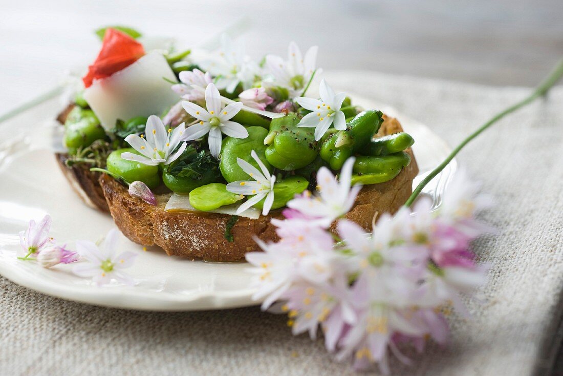 Belegtes Brot mit Saubohnen, Kräutern und Essblüten