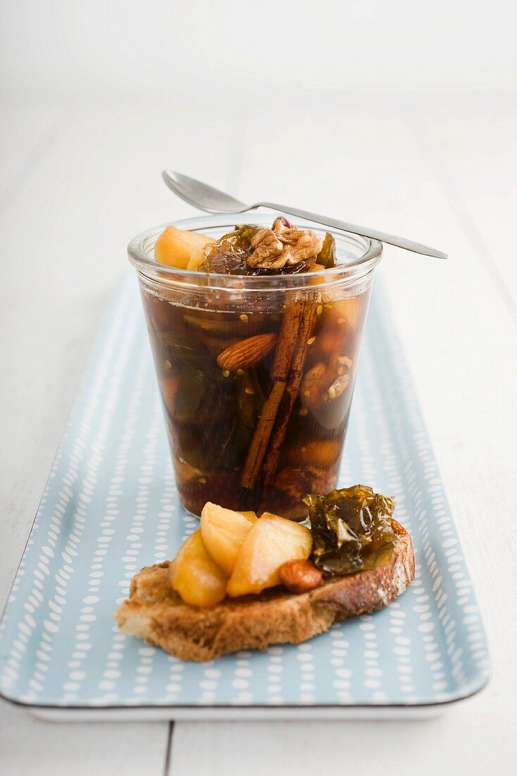 Green tomato chutney in a glass and on a slice of bread