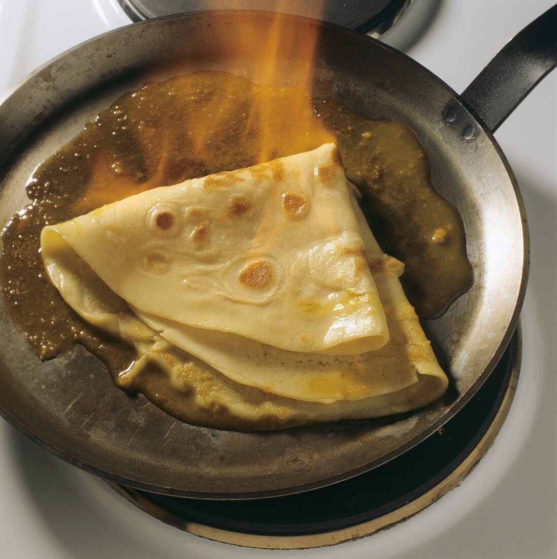 Crepes Suzette mit Orangenbutter in Pfanne flambiert