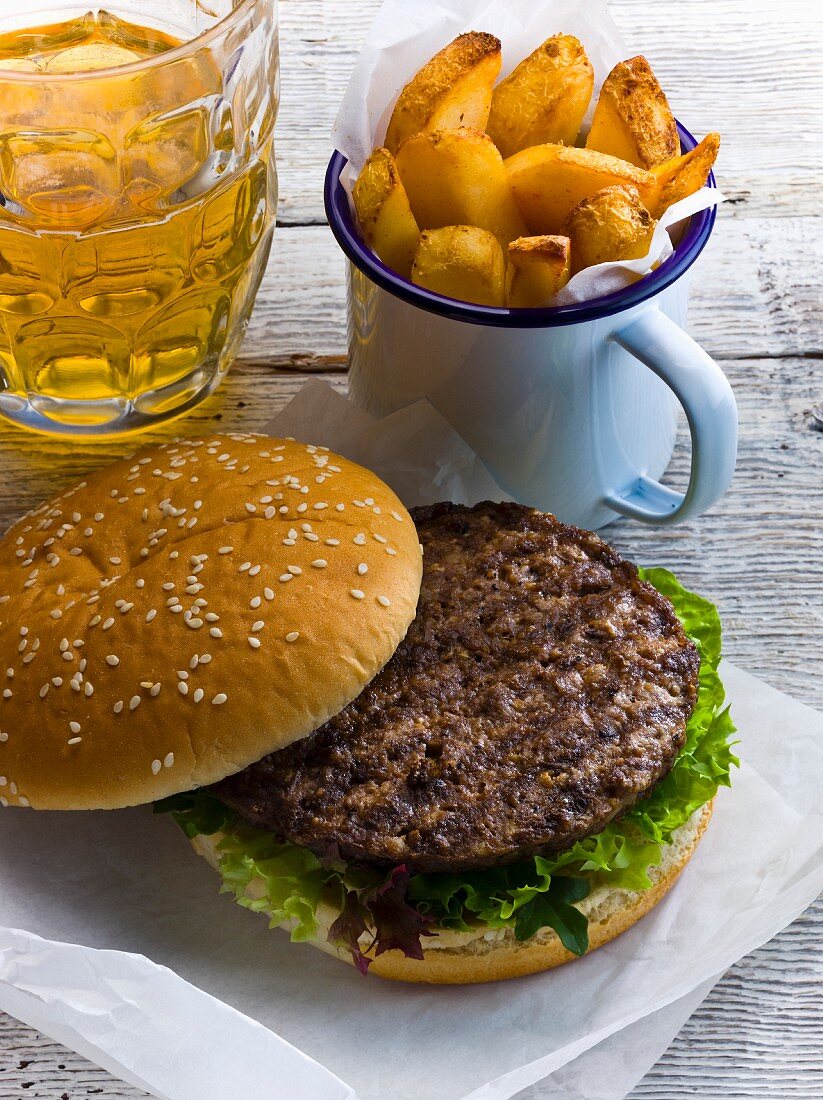 Beefburger mit Pommes frites und Bierglas