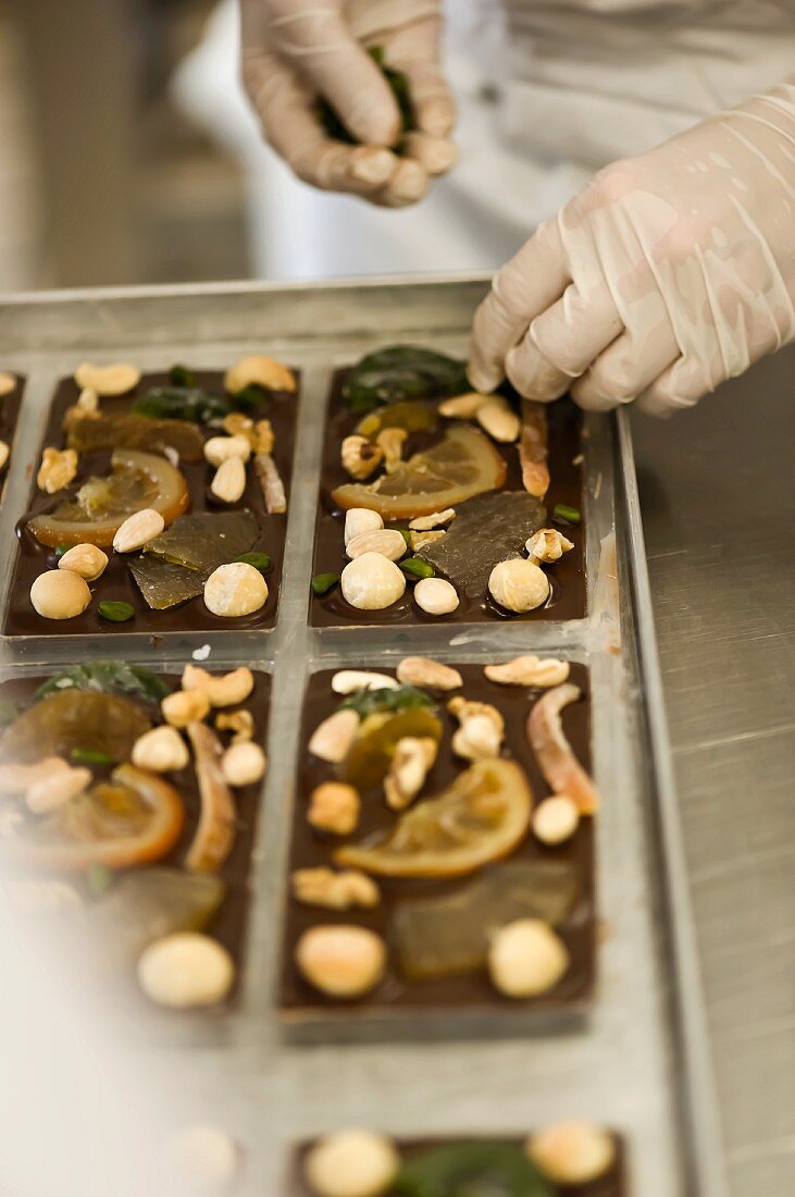 Preparing bars of chocolate with candied fruits and nuts
