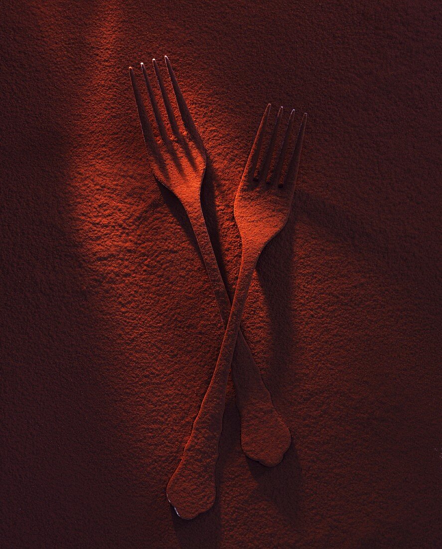 Two forks dusted with cocoa powder