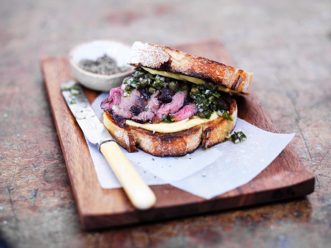 A grilled venison and green sauce sandwich