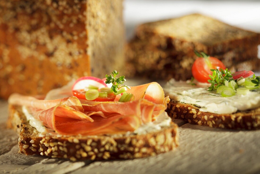 Slices of wholemeal bread topped with ham, herb quark and vegetables