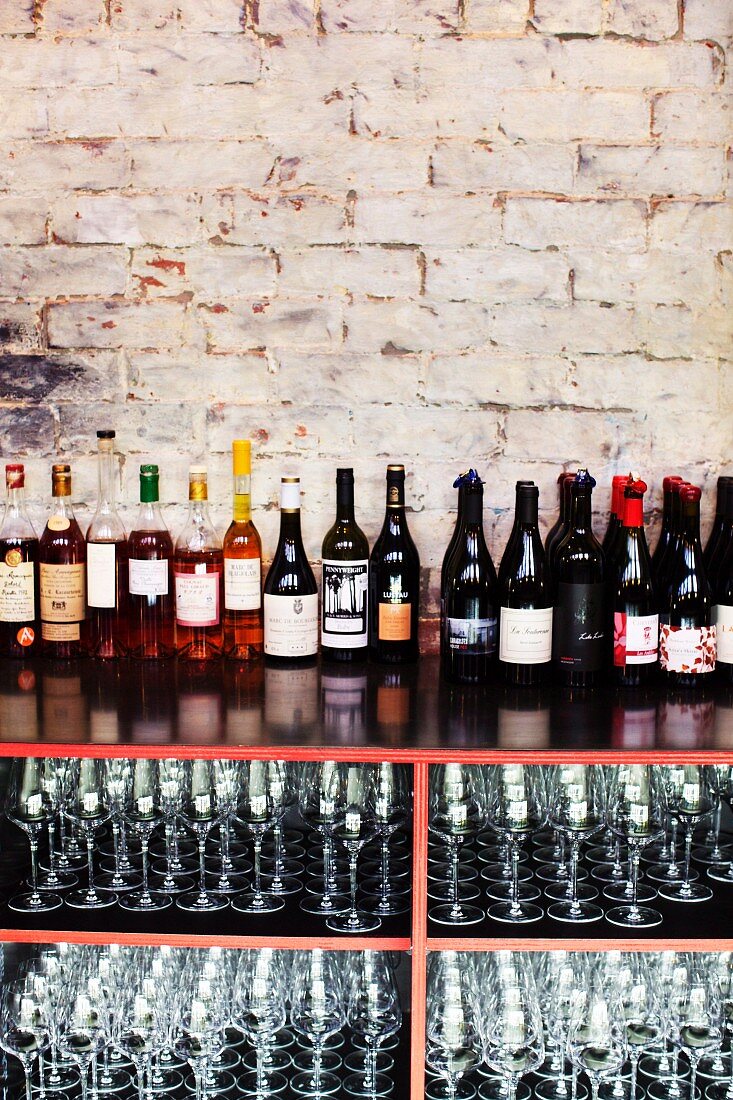 Various bottles of wine and empty glasses in a restaurant