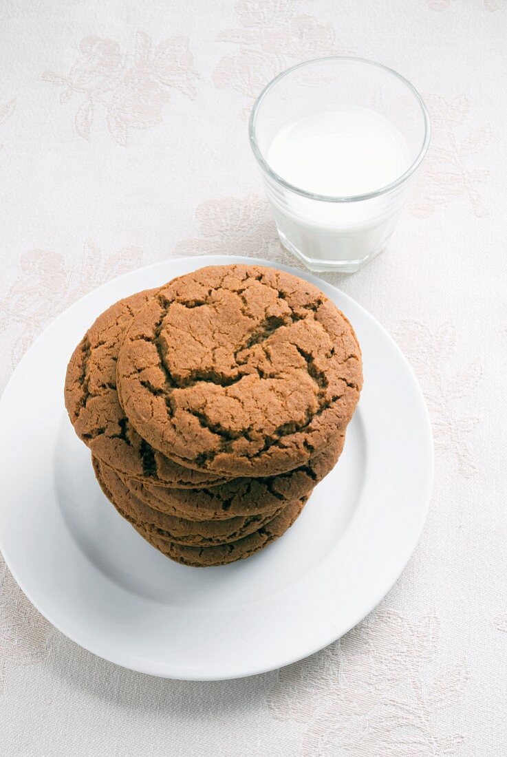 Stack of Molasses Cookies on a Plate with a Glass of Milk