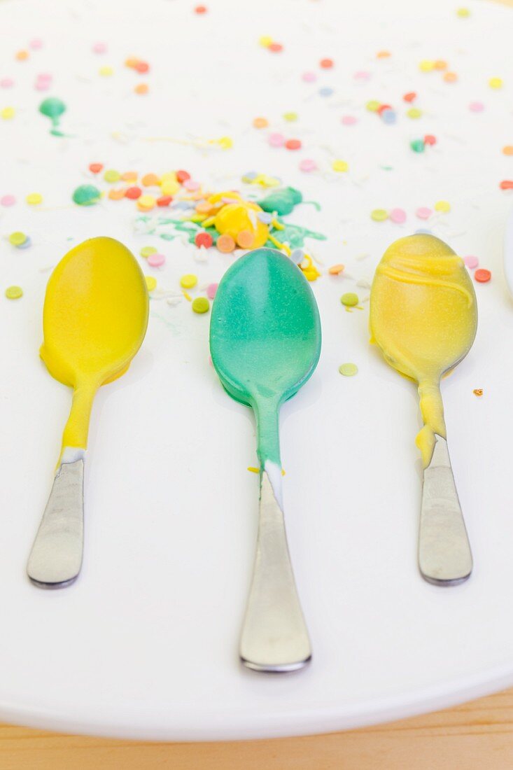 Yellow and green icing sugar on three spoons