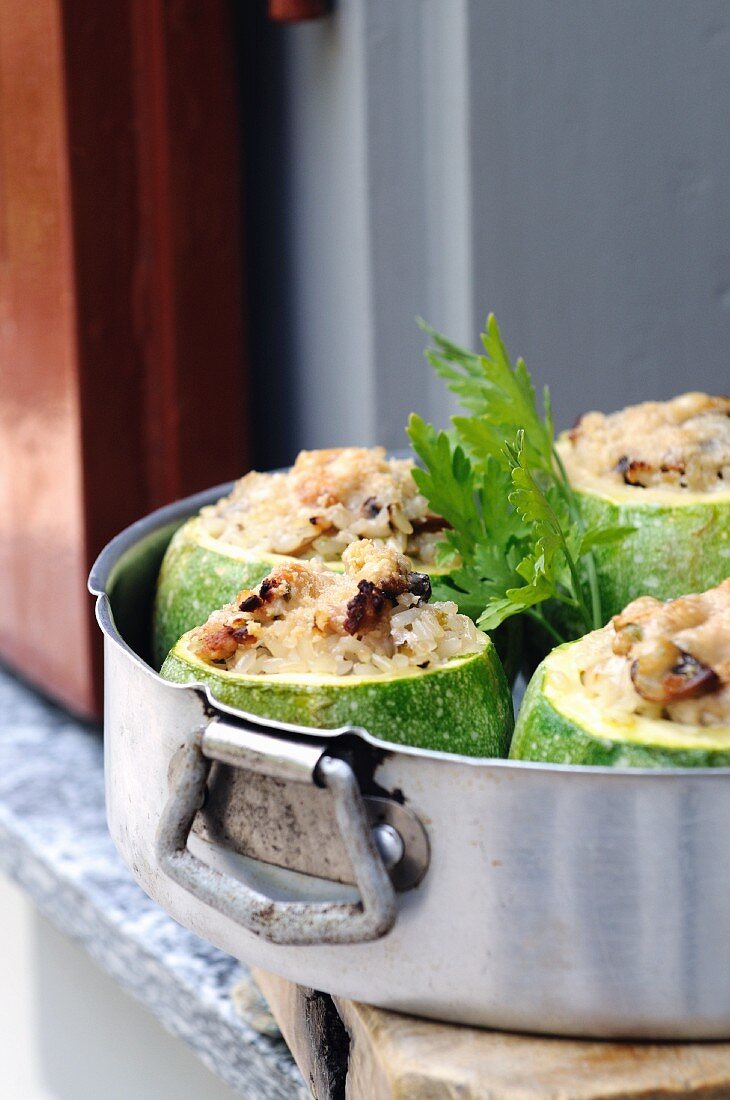 Round courgettes filled with rice in a baking tin