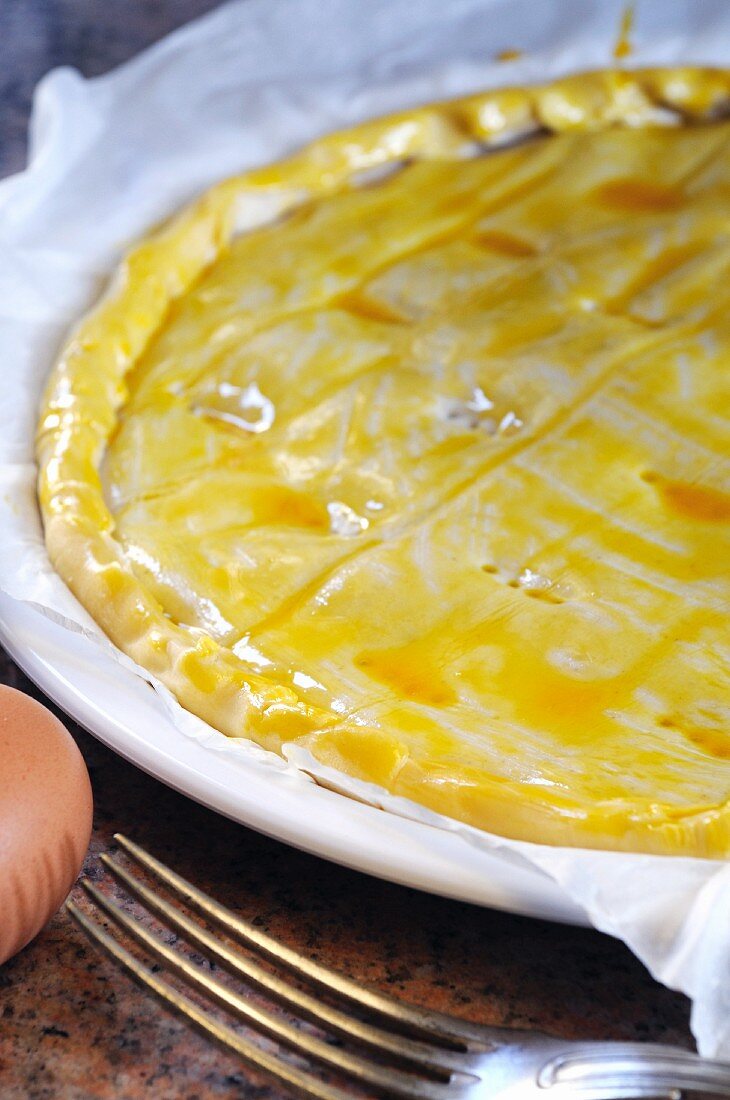 Spicy quiche being brushed with egg yolk