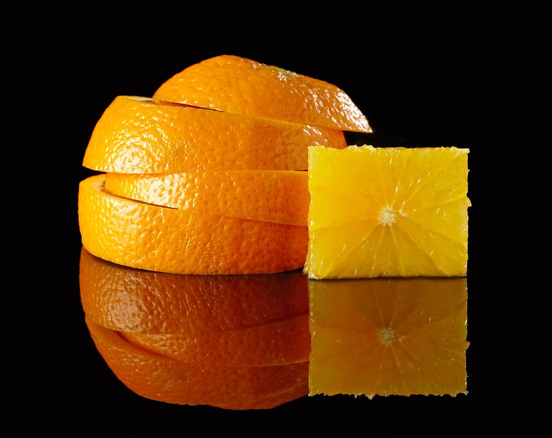 A stack of orange slices and a cube of fruit flesh