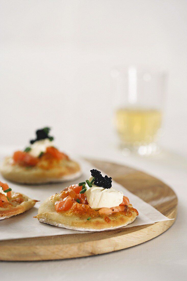 Mini pizzas topped with salmon, caviar and mozzarella