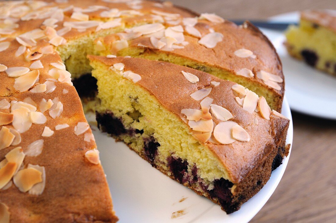 Sponge cake with blackberries and almonds, sliced